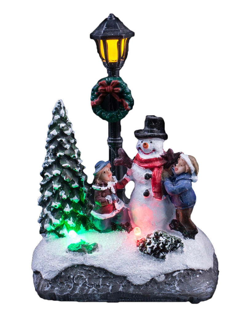 Beleuchtete Weihnachtsszene mit Kindern schmücken den Schneemann